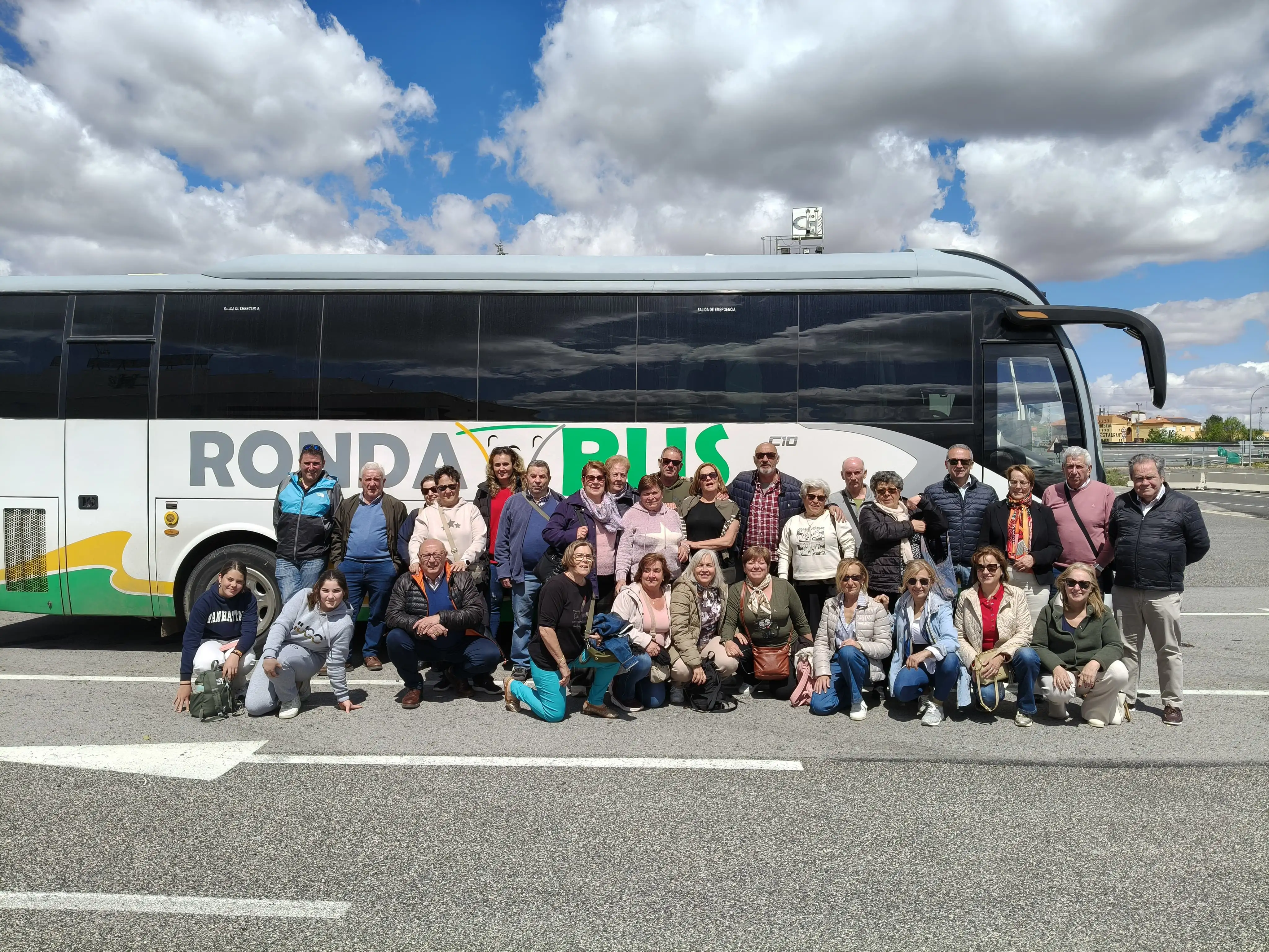Viajeros junto a un autocar de Rondabus